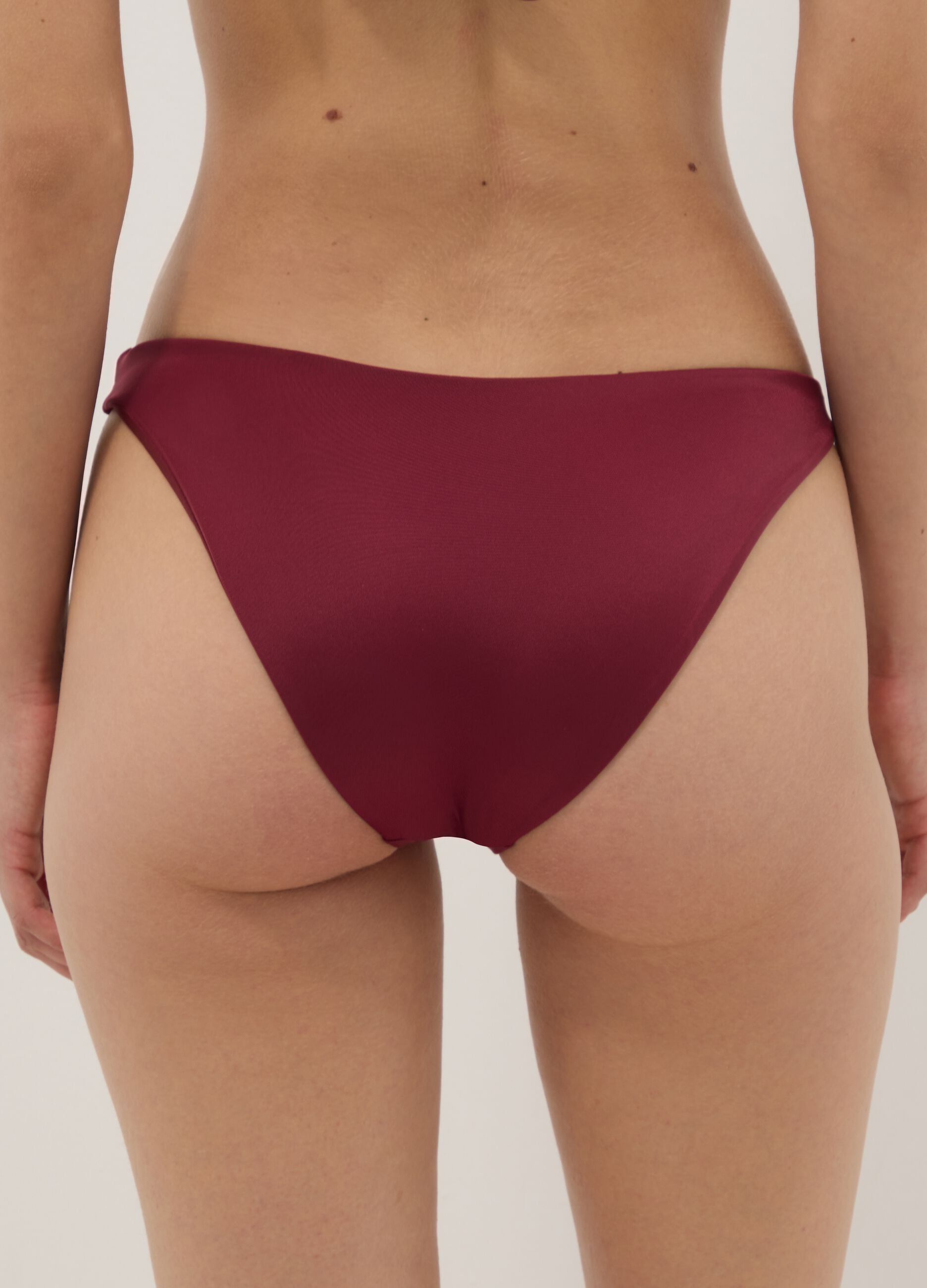 Red stretch bikini bottoms with gold-tone ring detail