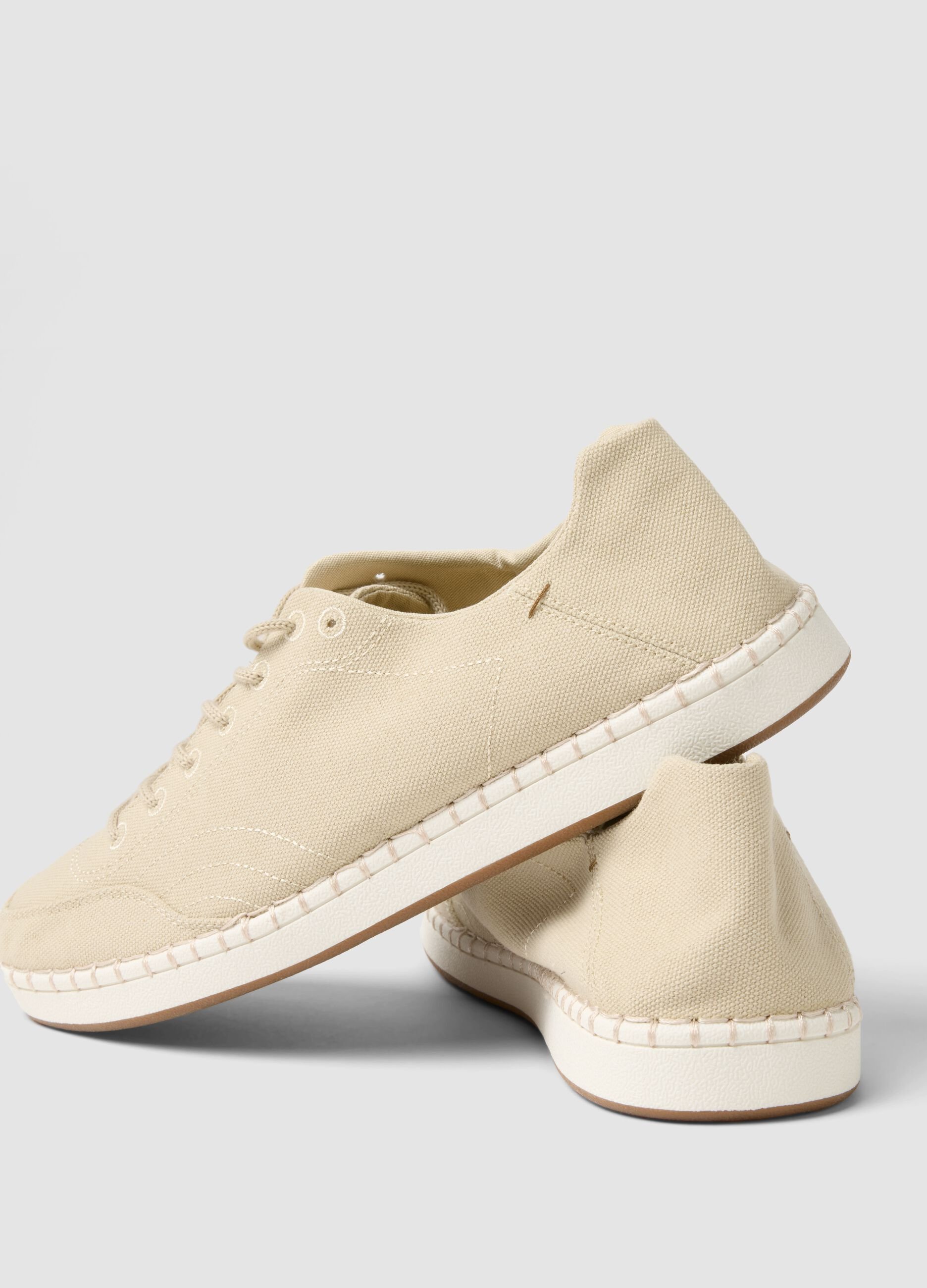 Beige lace-up trainers with visible stitching