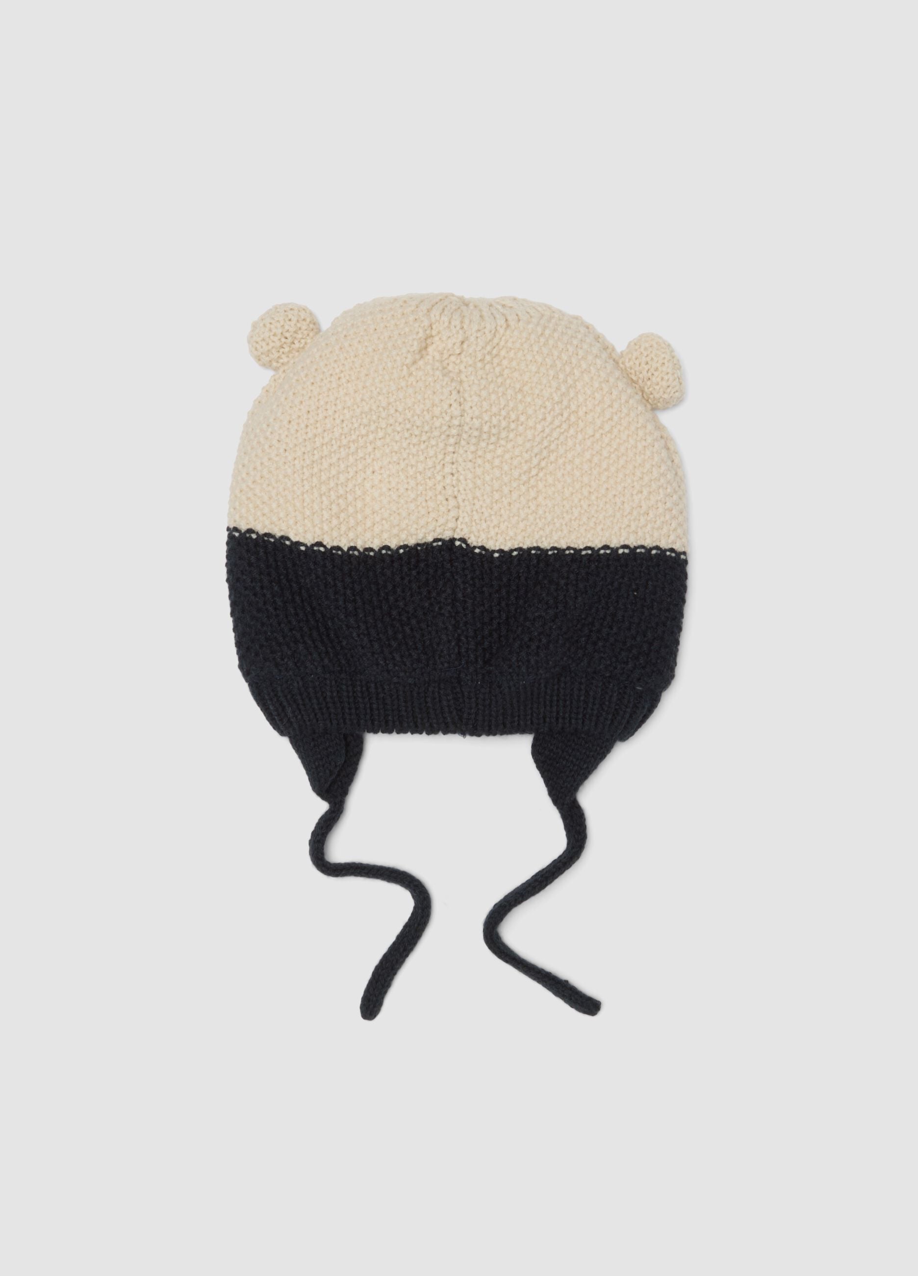 Blue knitted hat with teddy bear motif and ties