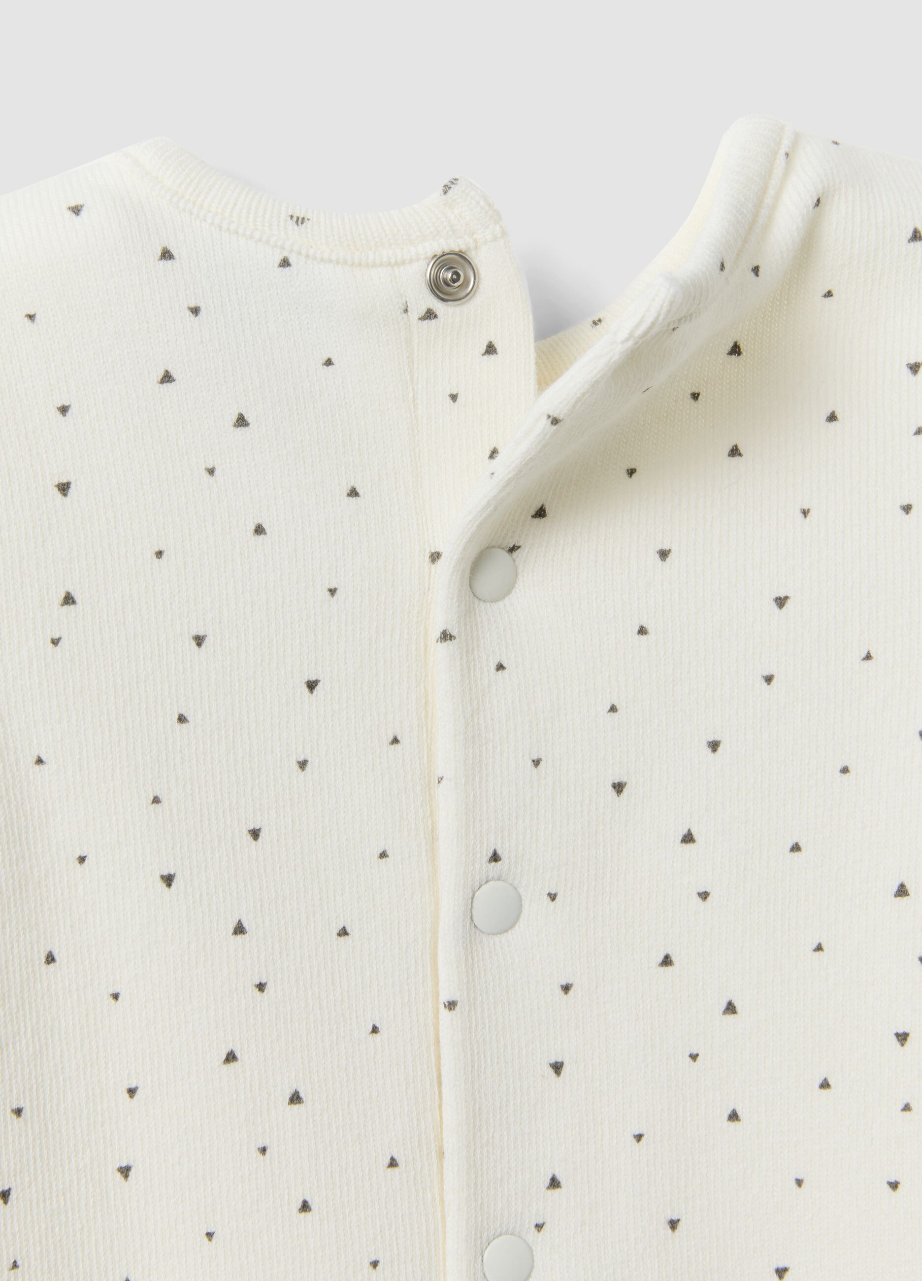 White organic cotton baby romper with buttons and pattern