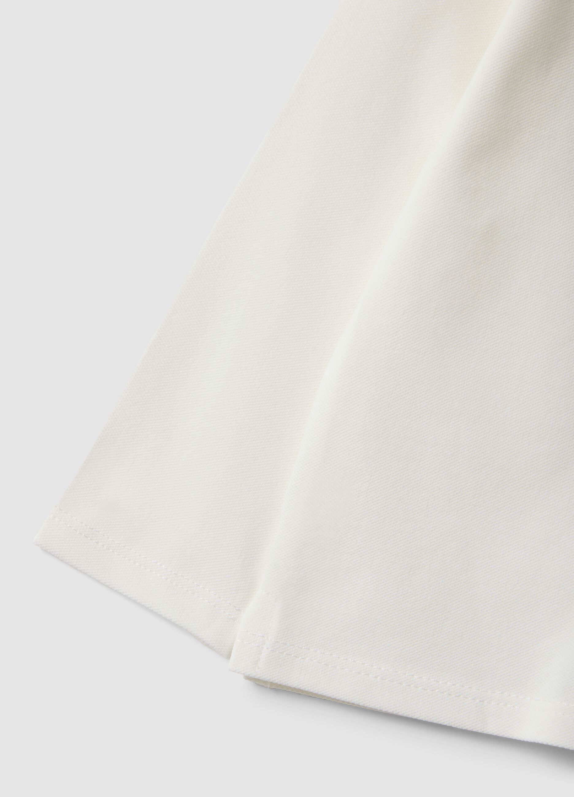 Polo bianca in cotone organico elasticizzato con dettagli volant per bimba