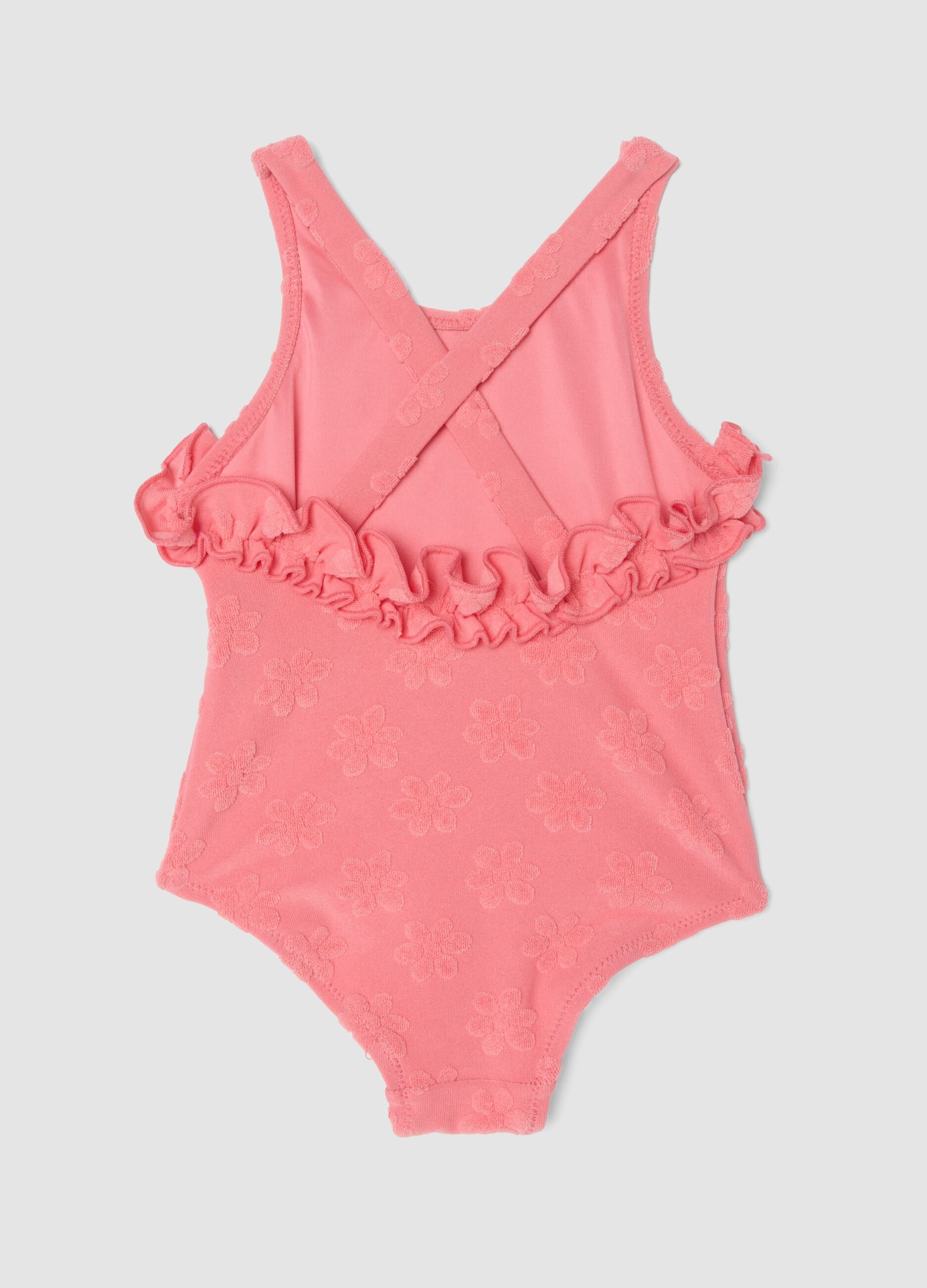 Pink stretch-fabric one-piece swimsuit for baby girls with floral detailing