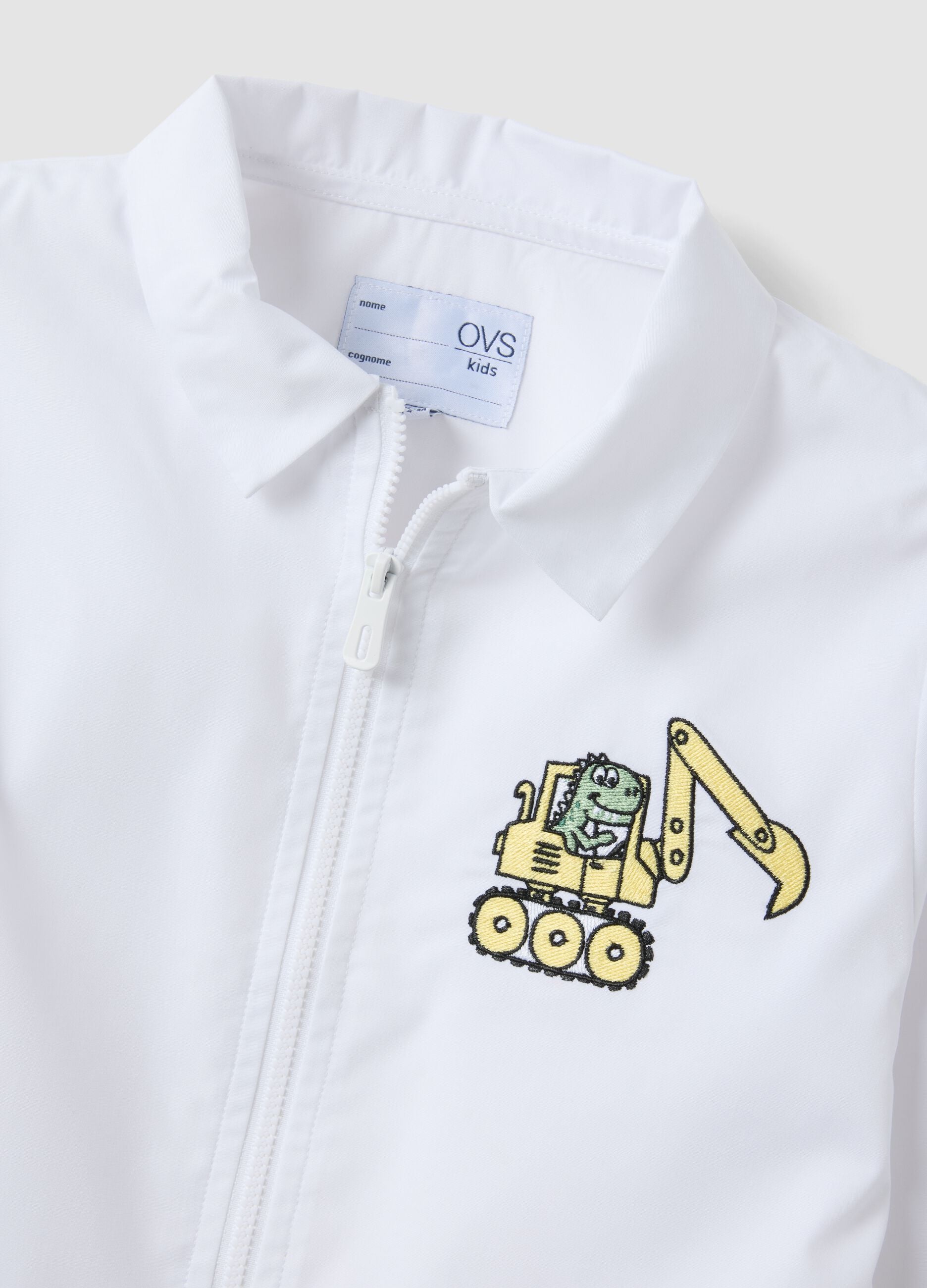 White nursery apron with zip and dinosaur embroidery for boys