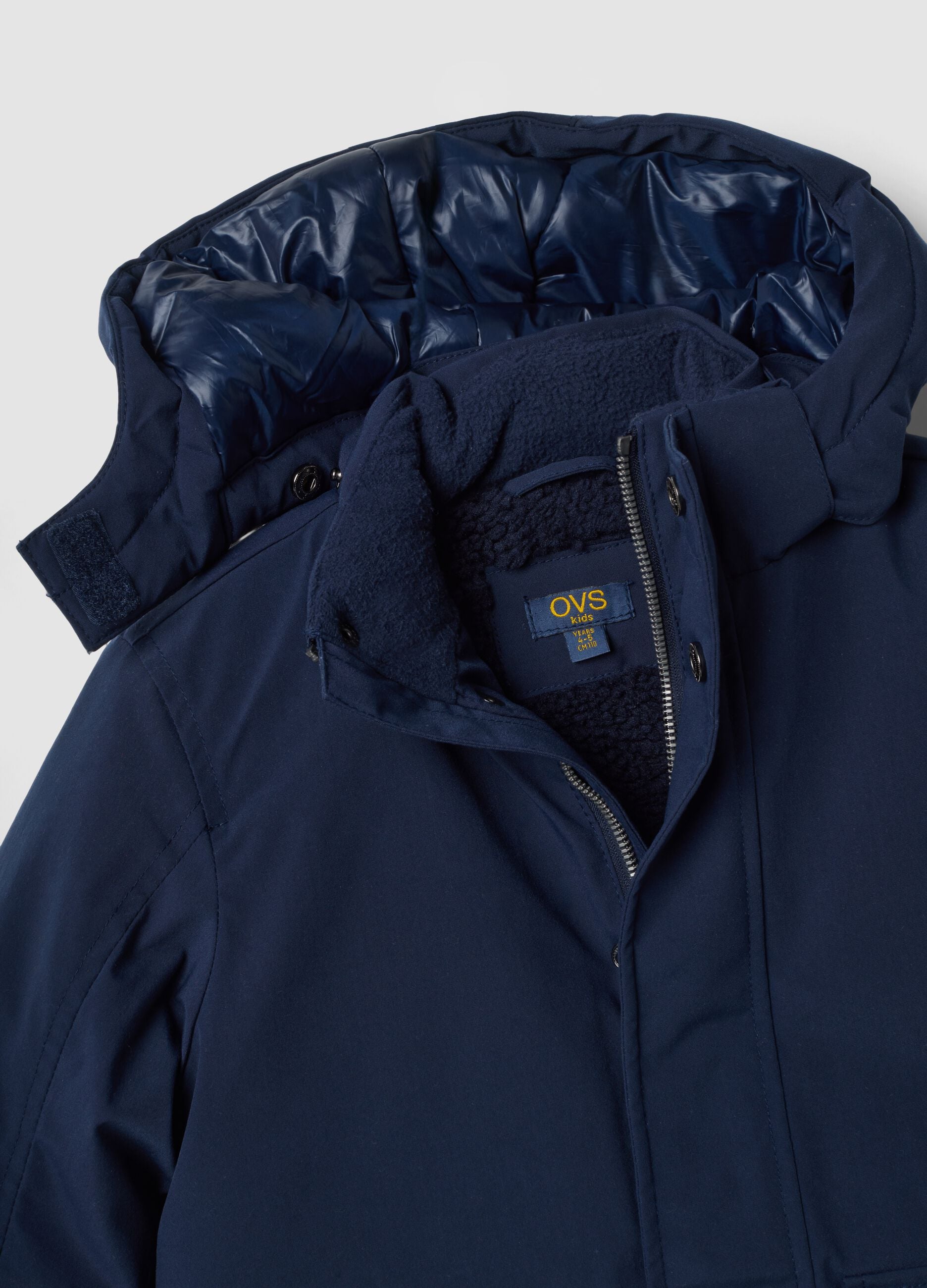 Long padded navy parka with detachable hood, oversized fit