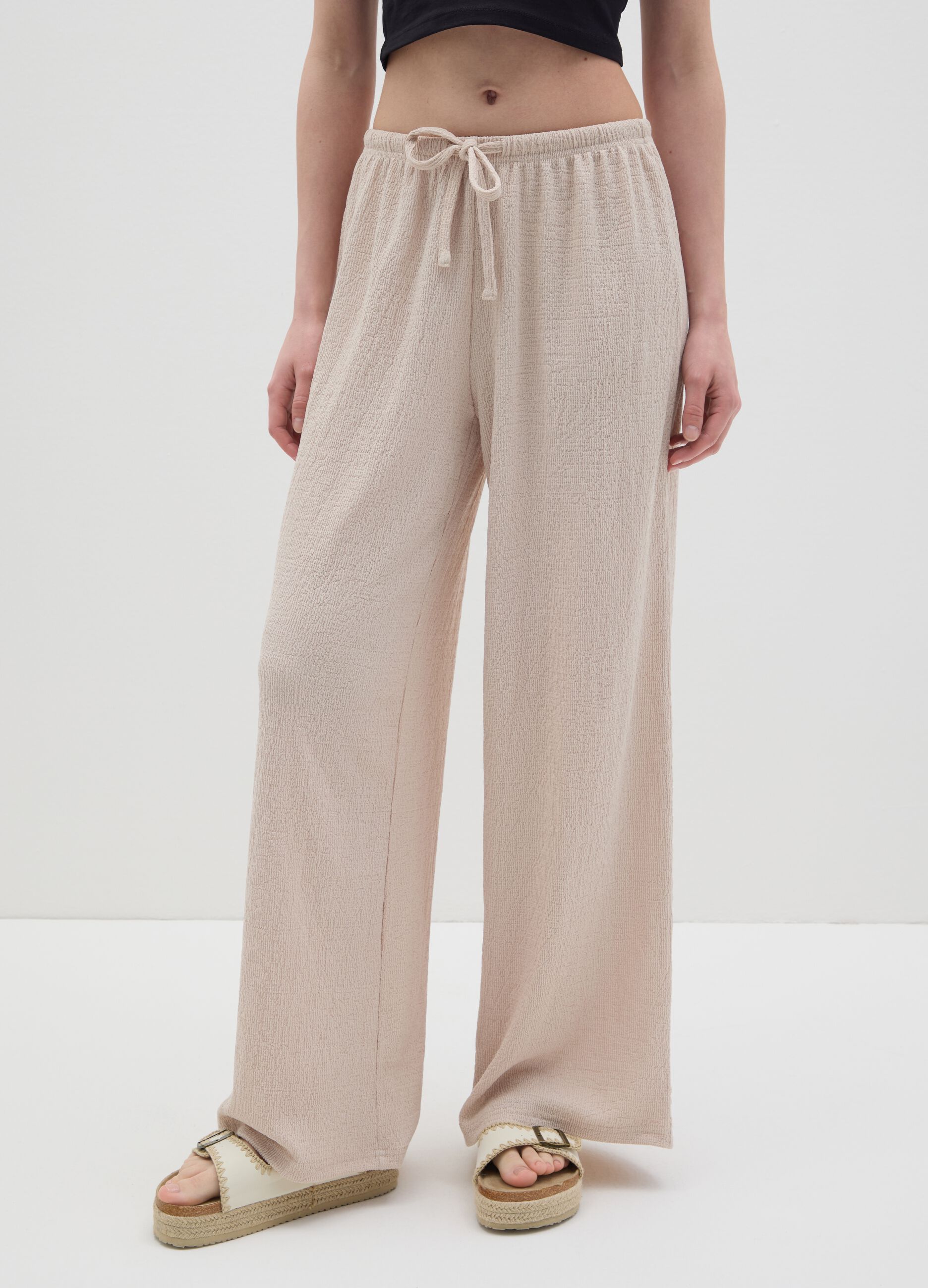 Women's beige regular-fit palazzo pants in stretch fabric.