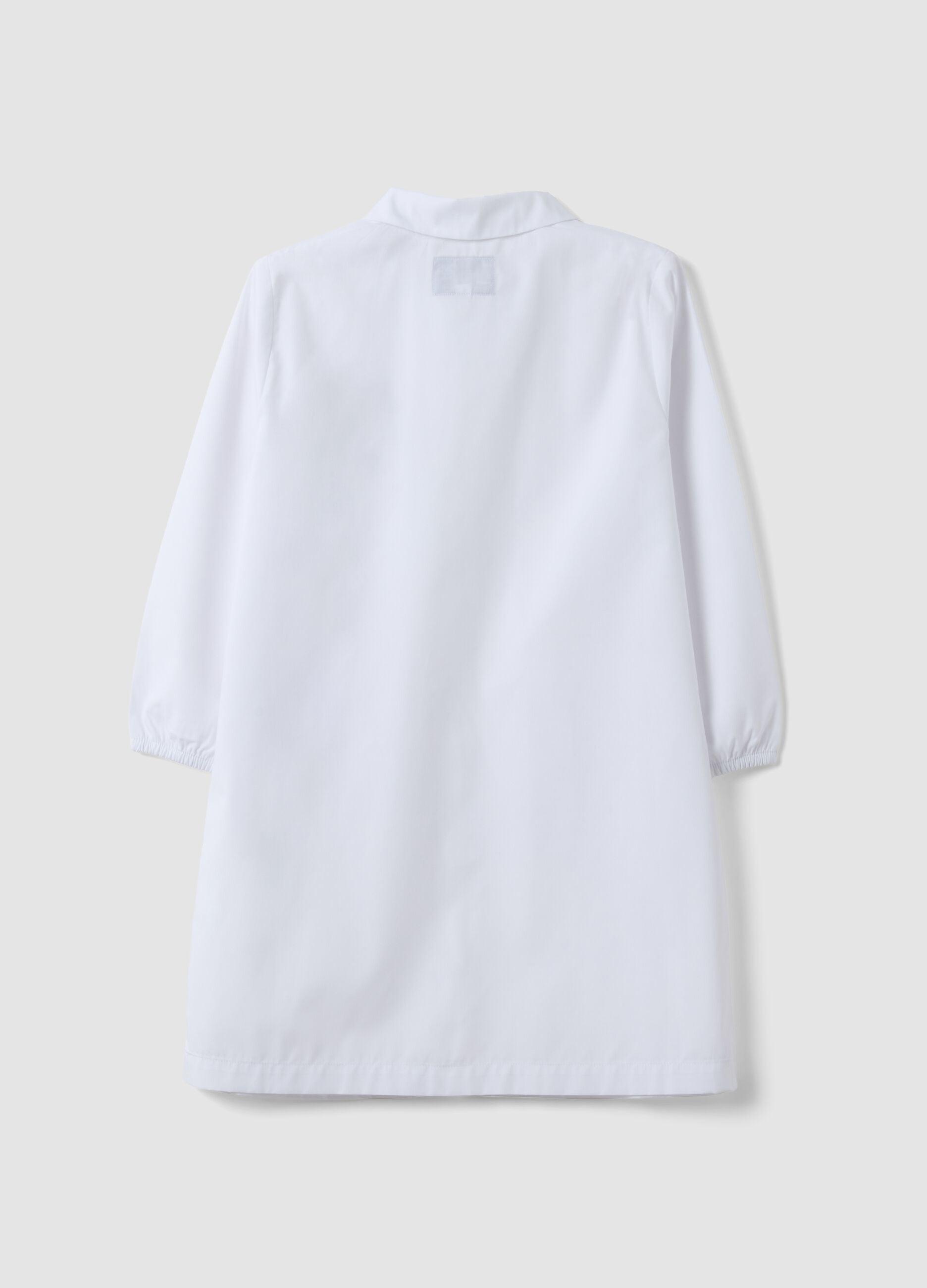 White nursery apron with zip and dinosaur embroidery for boys