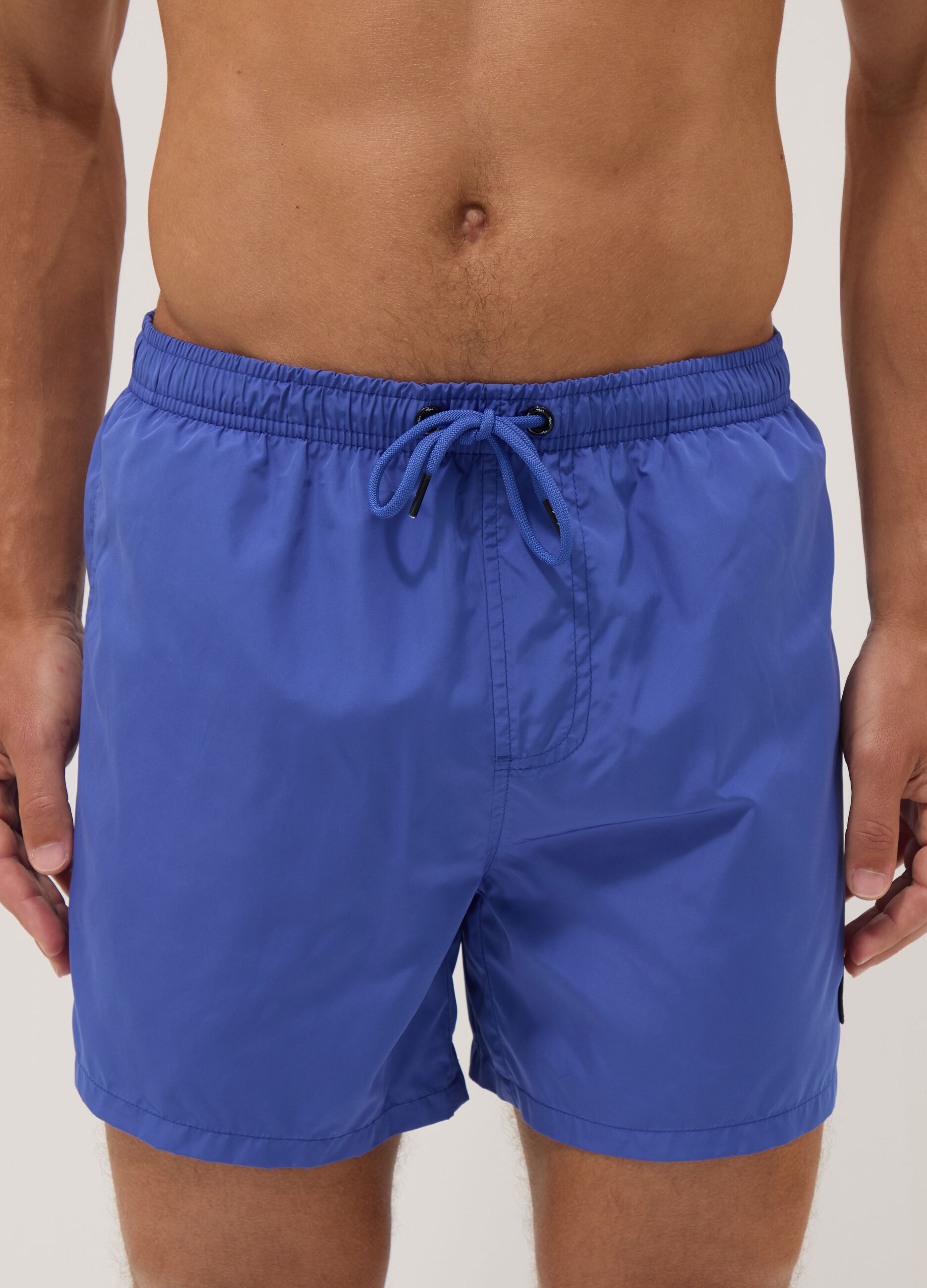 Blue swim shorts with elasticated waistband and drawstring