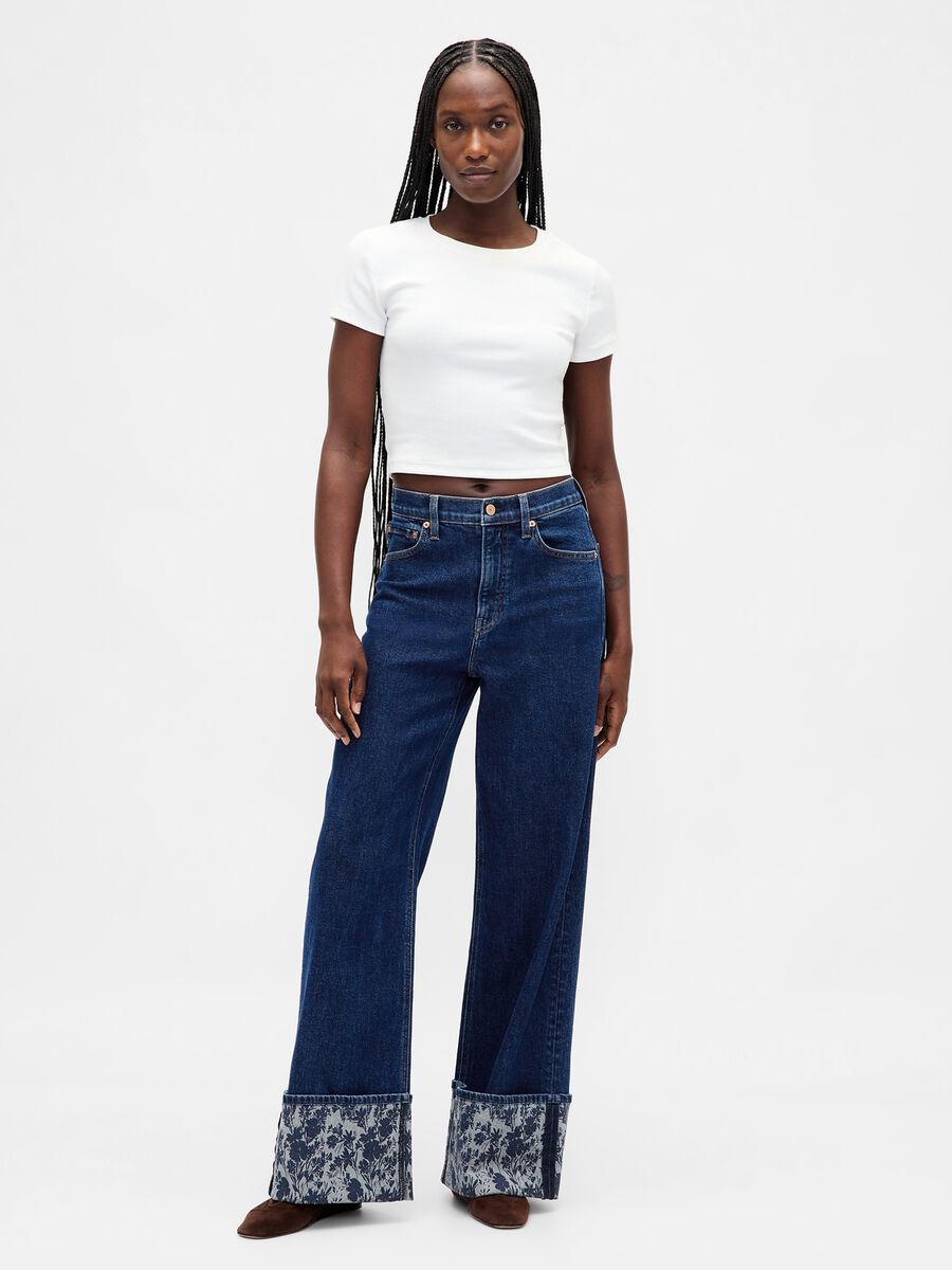Pantaloni larghi in denim con risvolto floreale_0