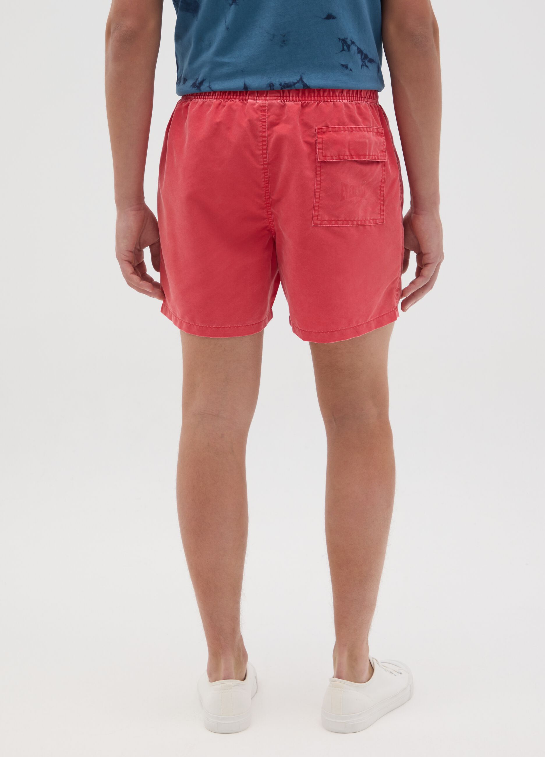 Red swimming trunks with logo print