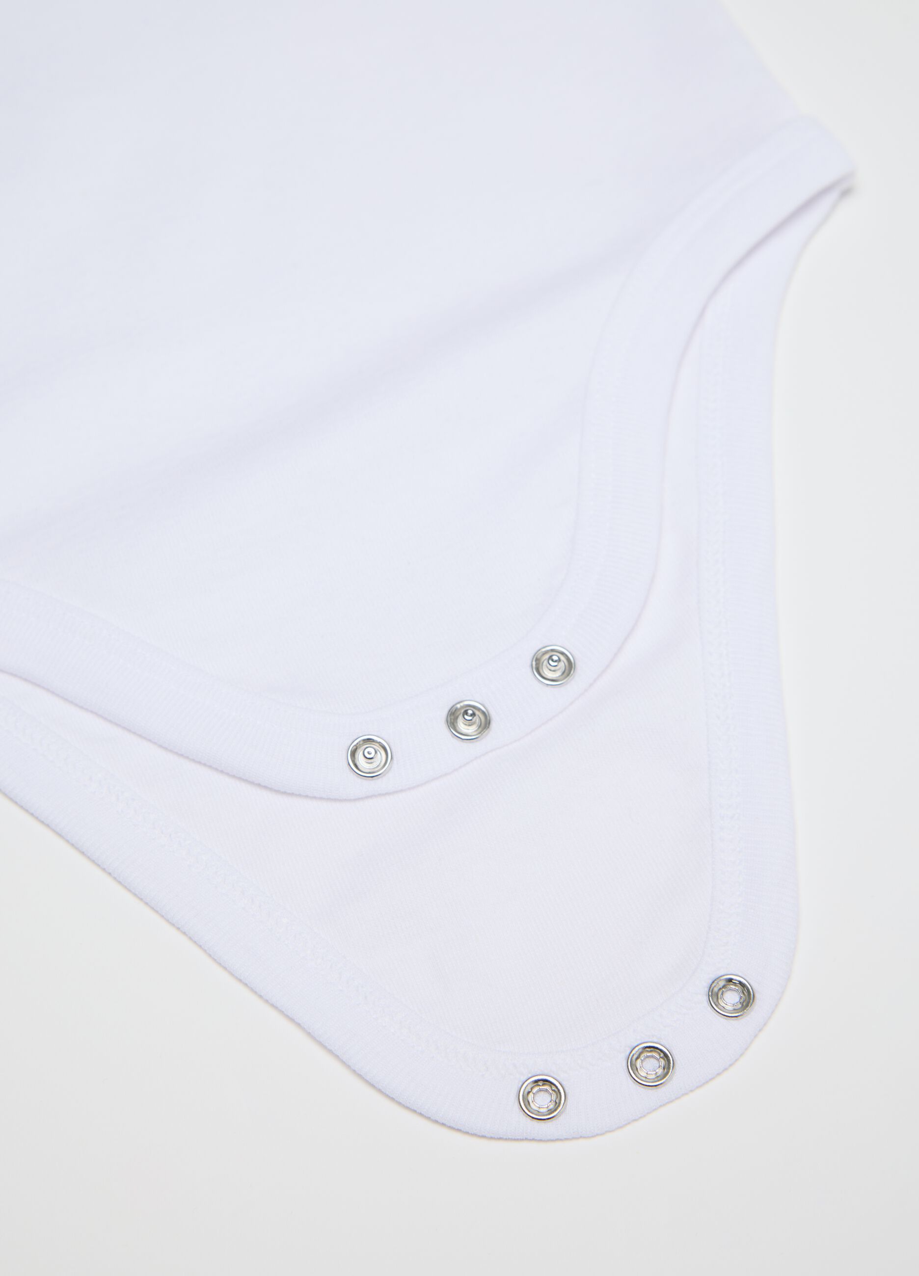 Three-pack white sleeveless bodysuits in organic cotton
