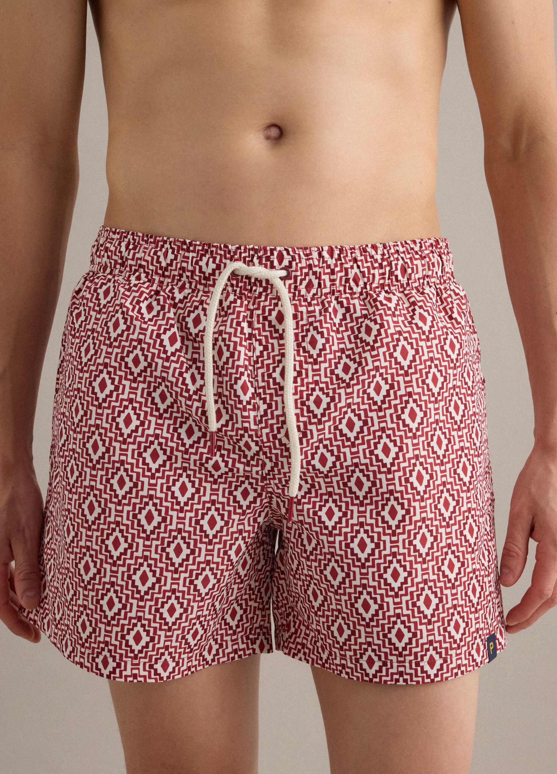 Red swim shorts with geometric print