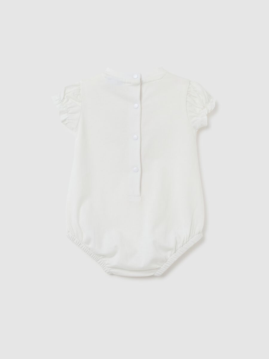 Newborn baby body in pure white cotton with ruffles_1