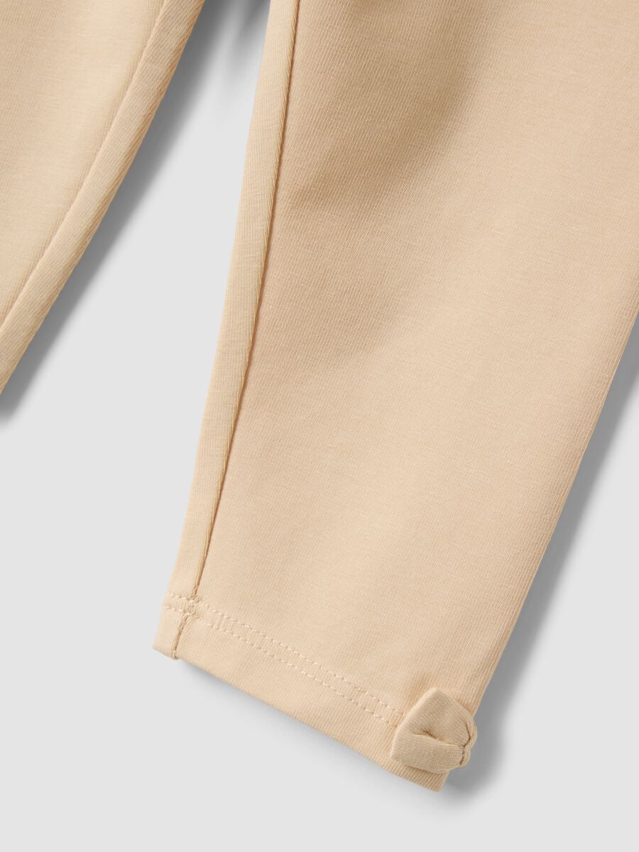 Leggings beige in cotone organico elasticizzato con fiocchi per bimba_2