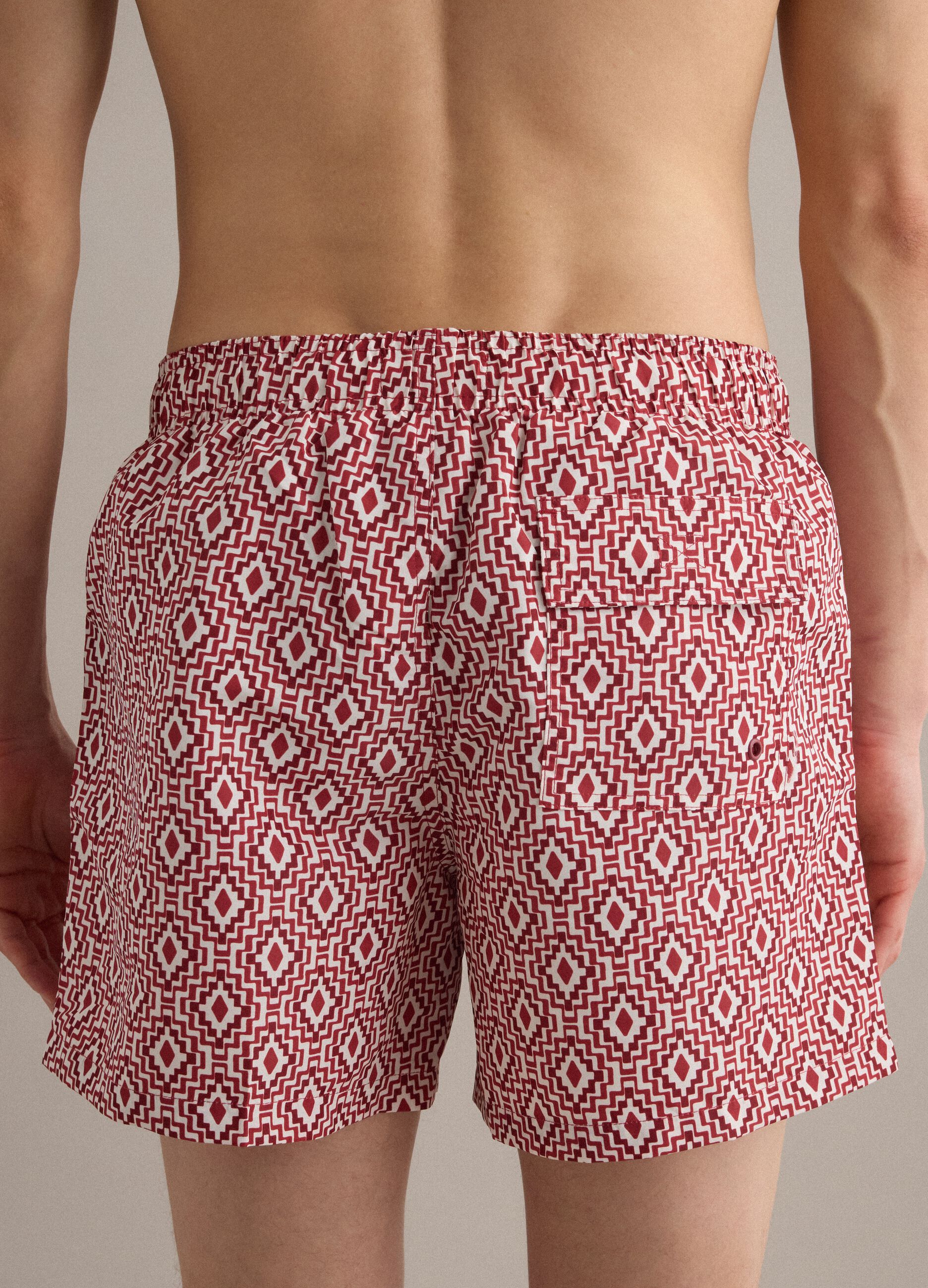 Red swim shorts with geometric print