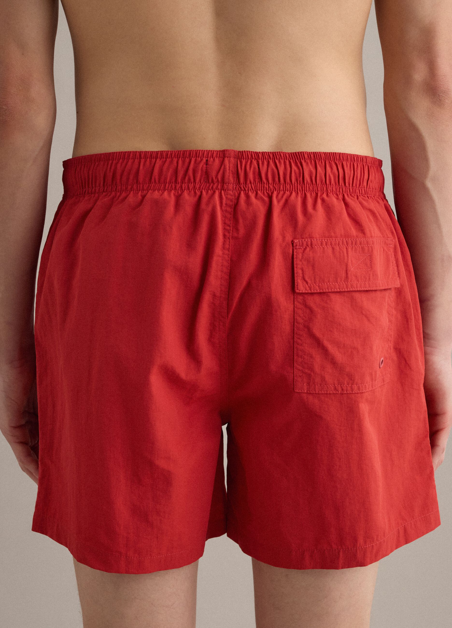 Red swim shorts with elasticated waistband and drawstring