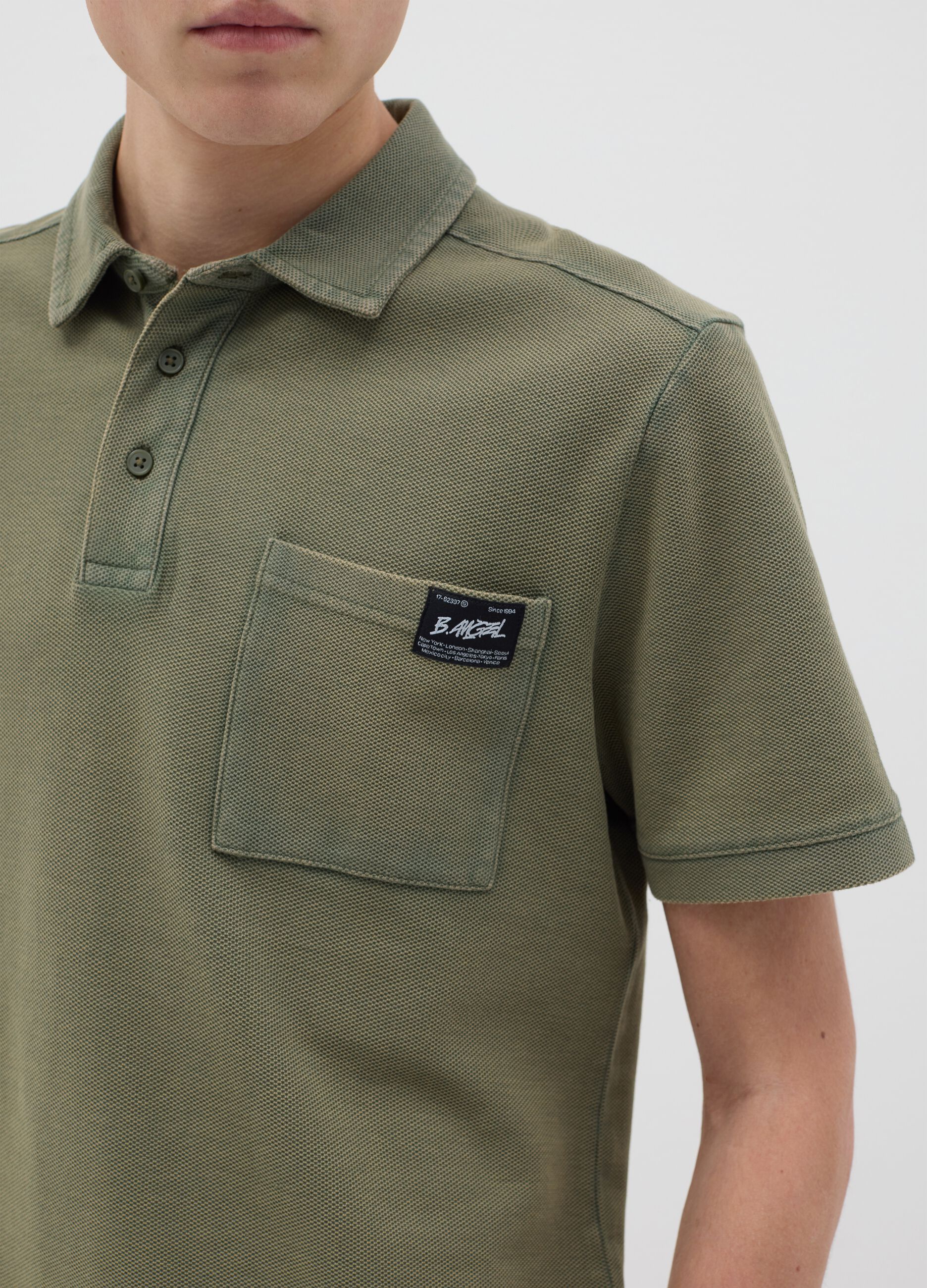 Green short-sleeved polo shirt in cotton piquet