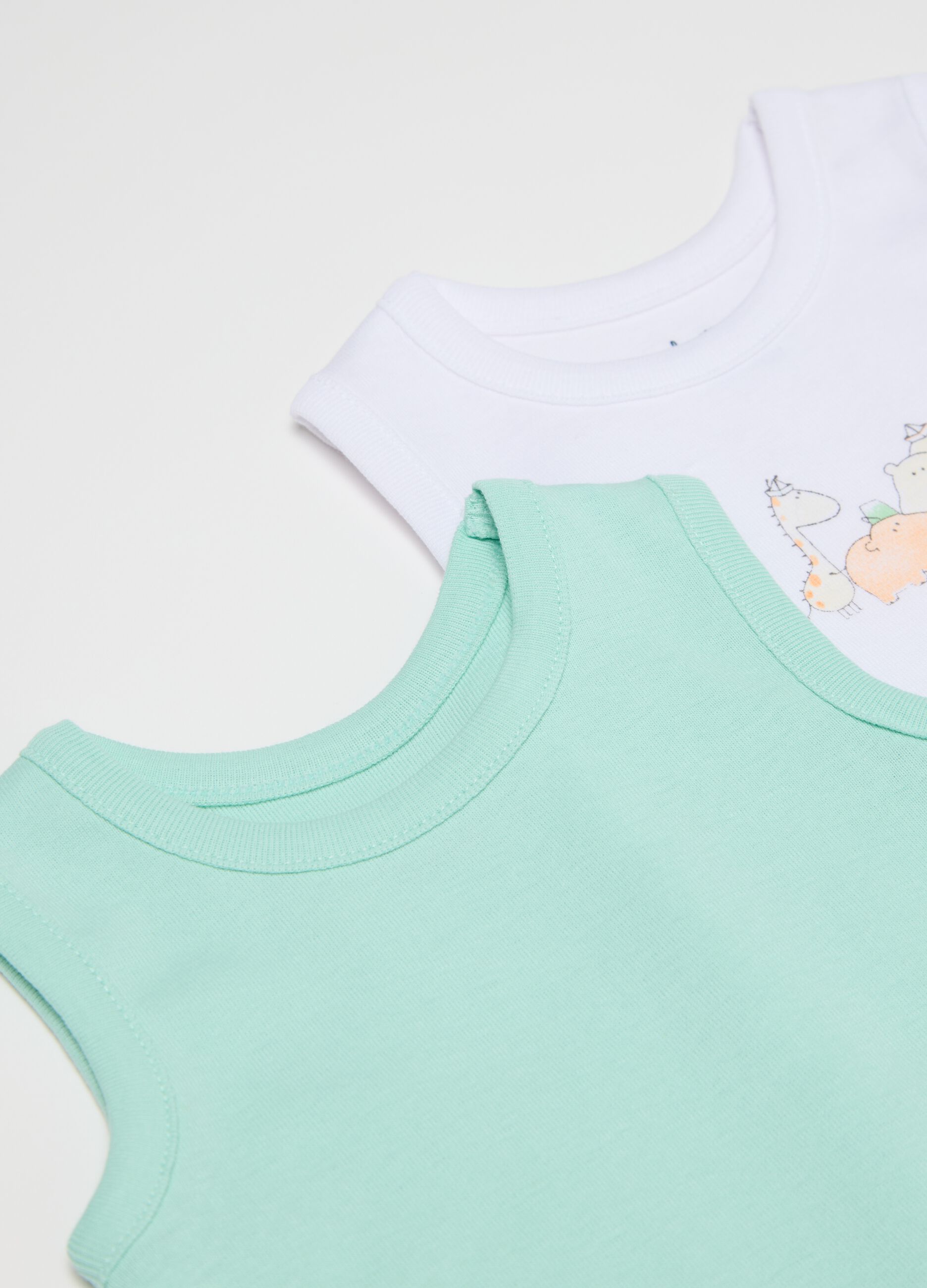 Three-pack white and green sleeveless bodysuits in organic cotton with print