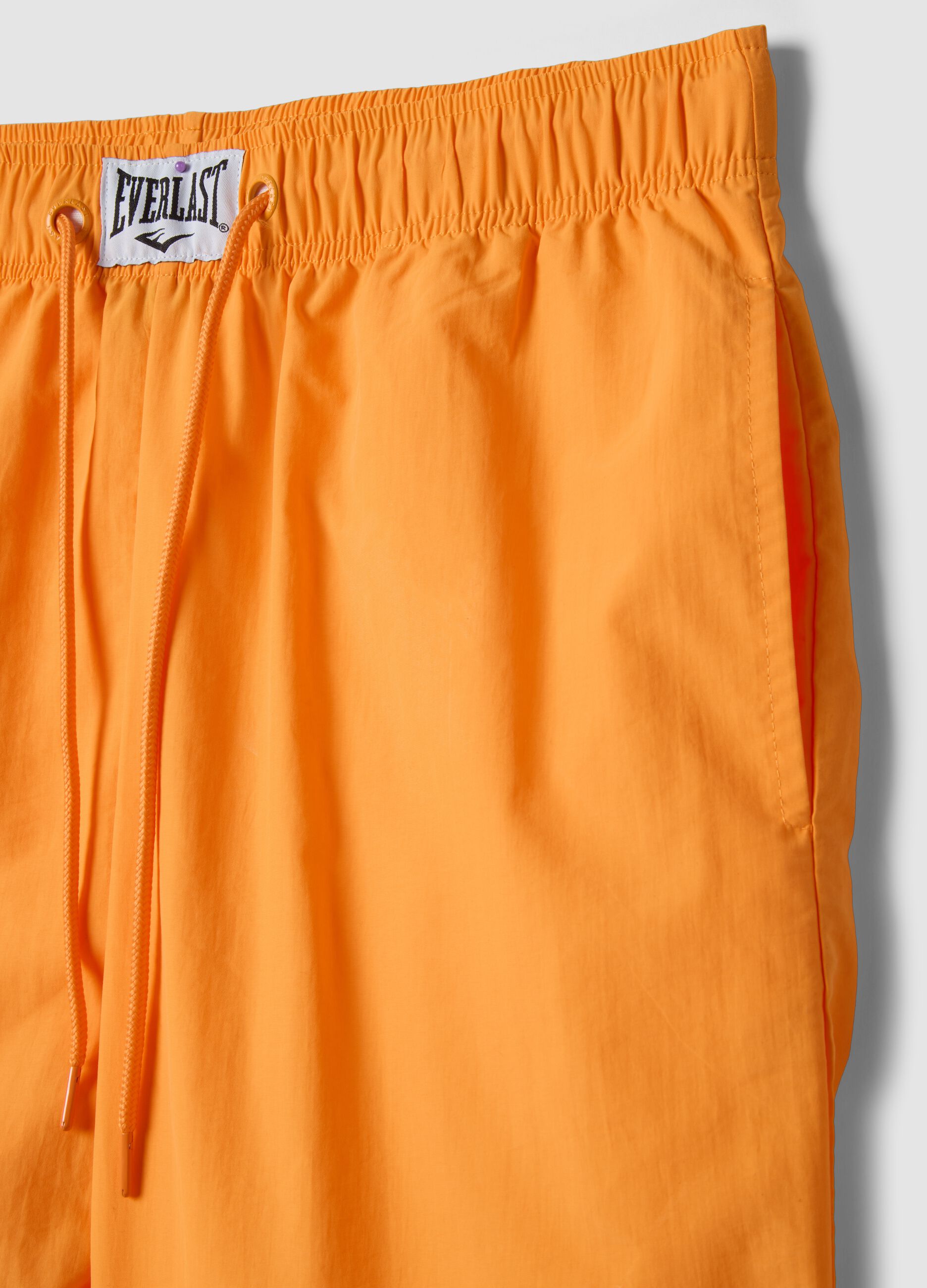Orange regular fit sports shorts with white and black details