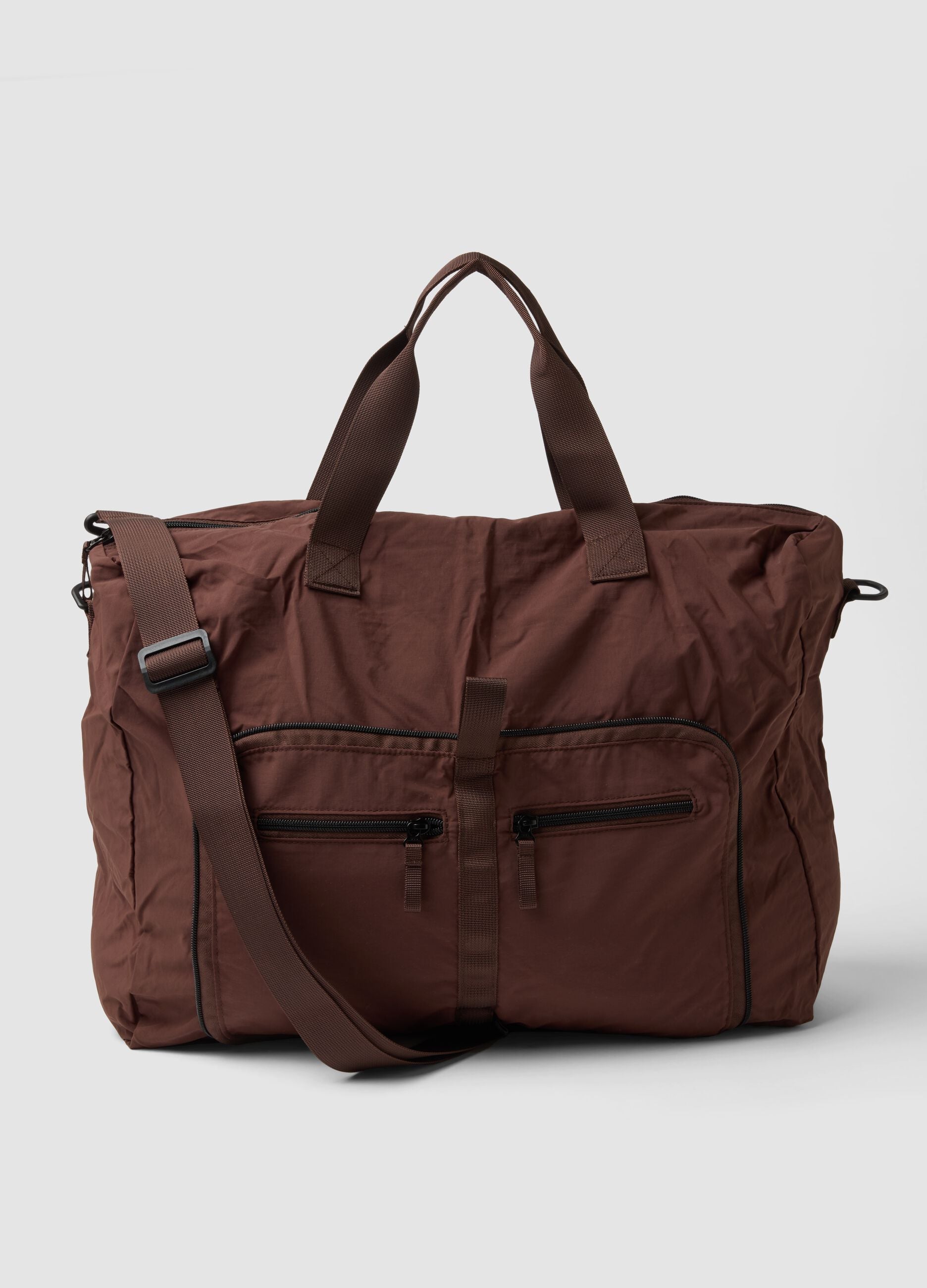 Brown foldable travel bag with shoulder strap and zip pockets