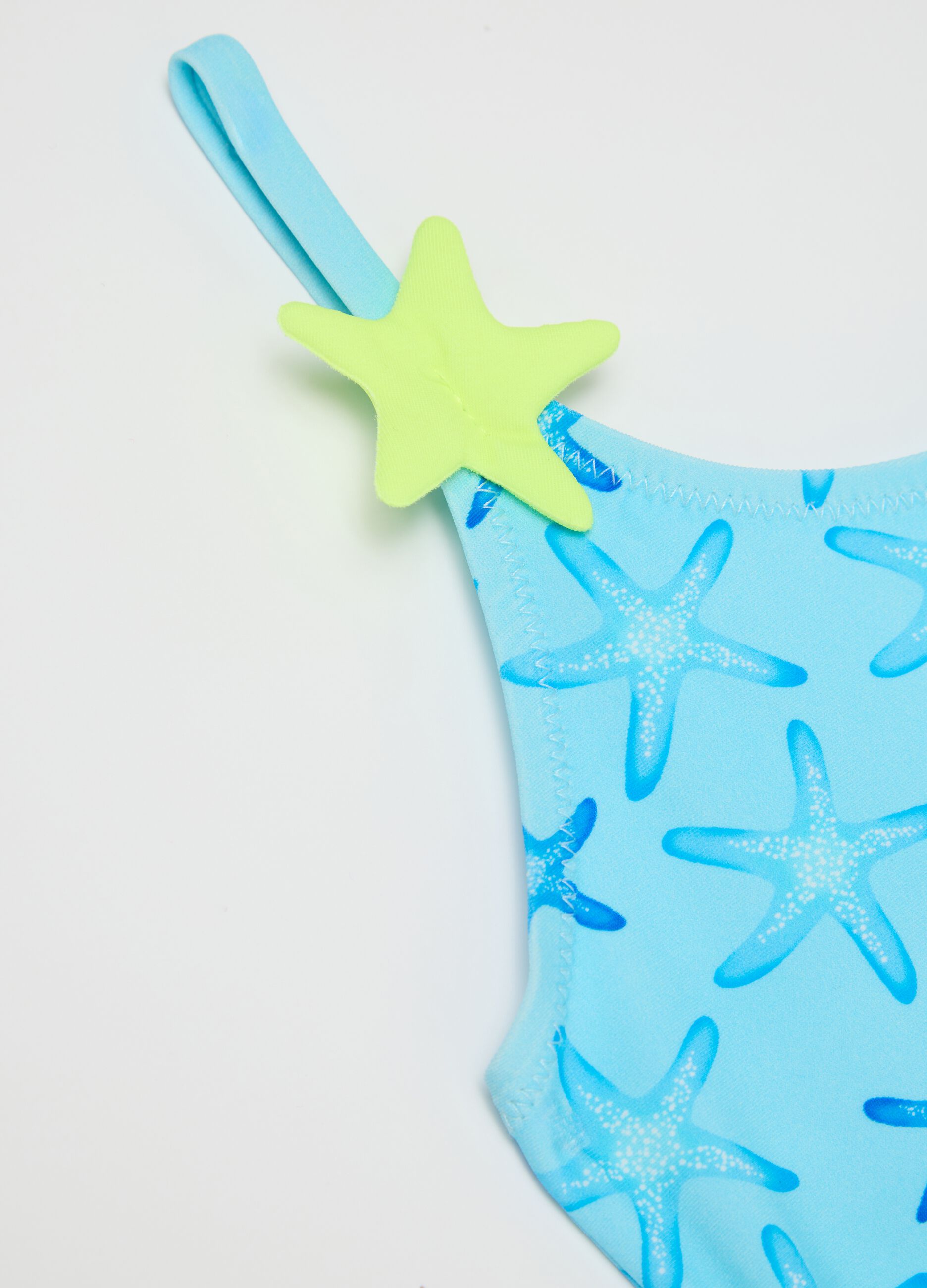 Girls’ one-piece swimsuit in light blue stretch fabric with starfish design