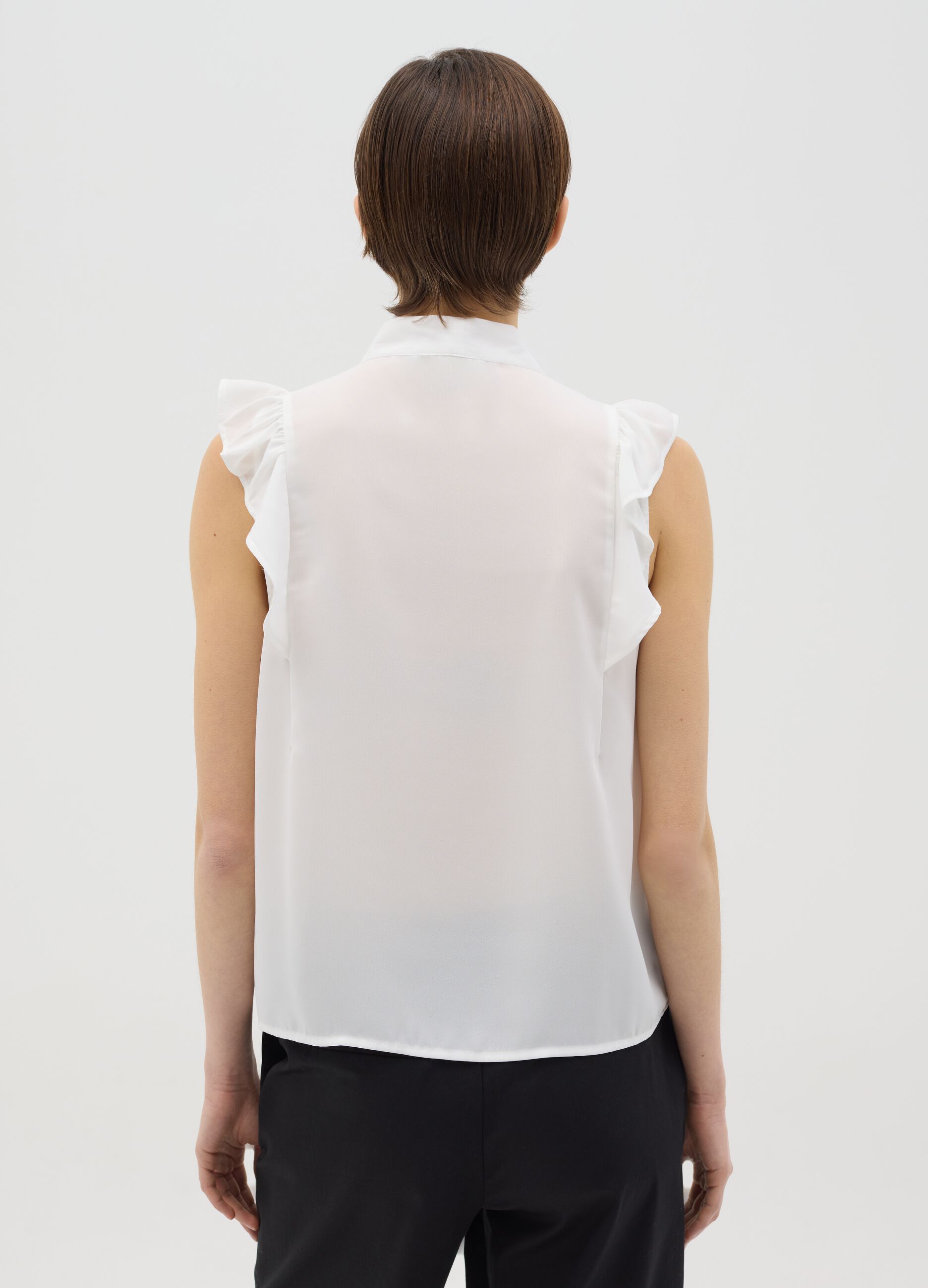 White sleeveless blouse with flounce