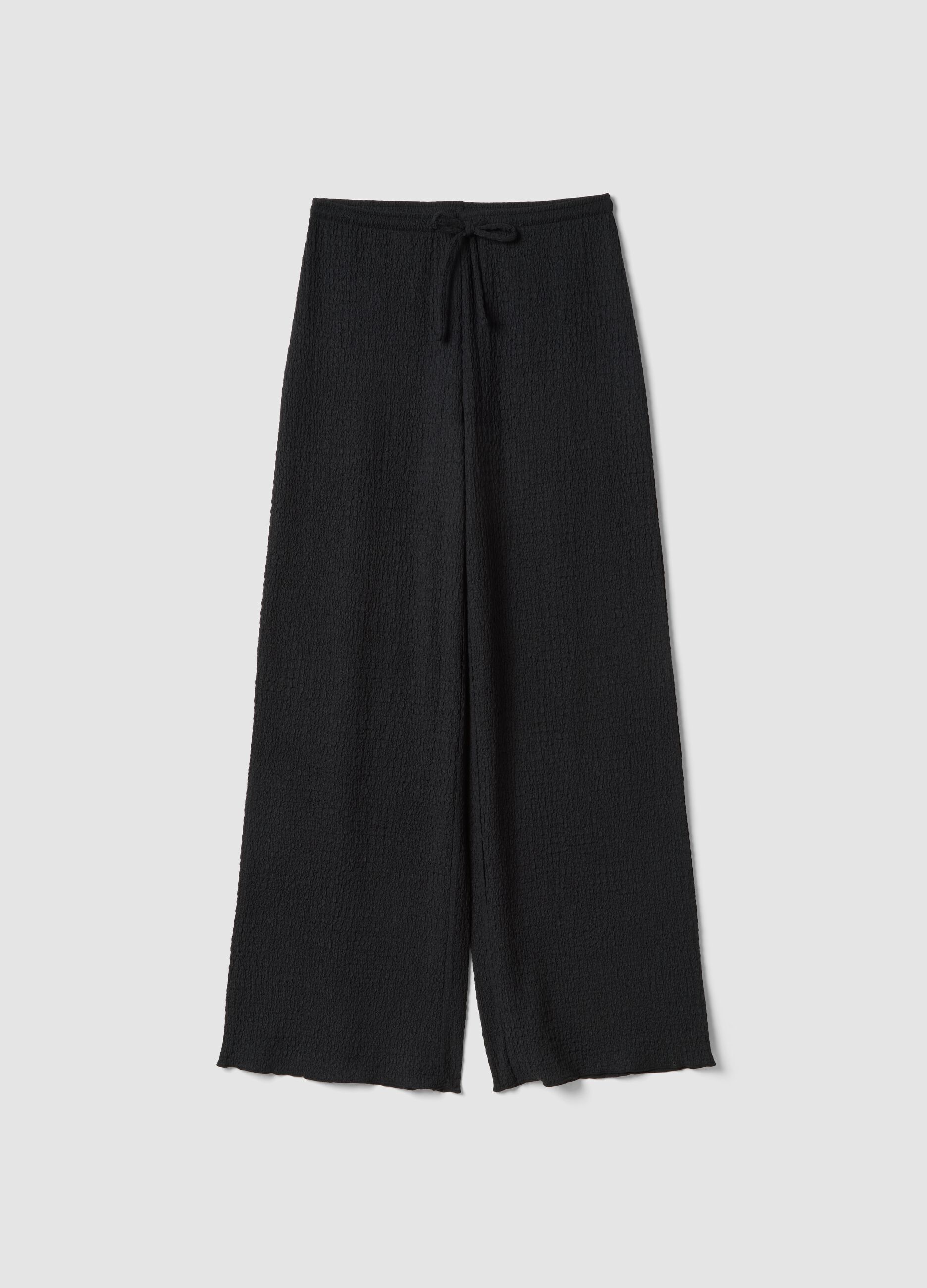 Black stretchy wide-leg trousers with crinkled texture