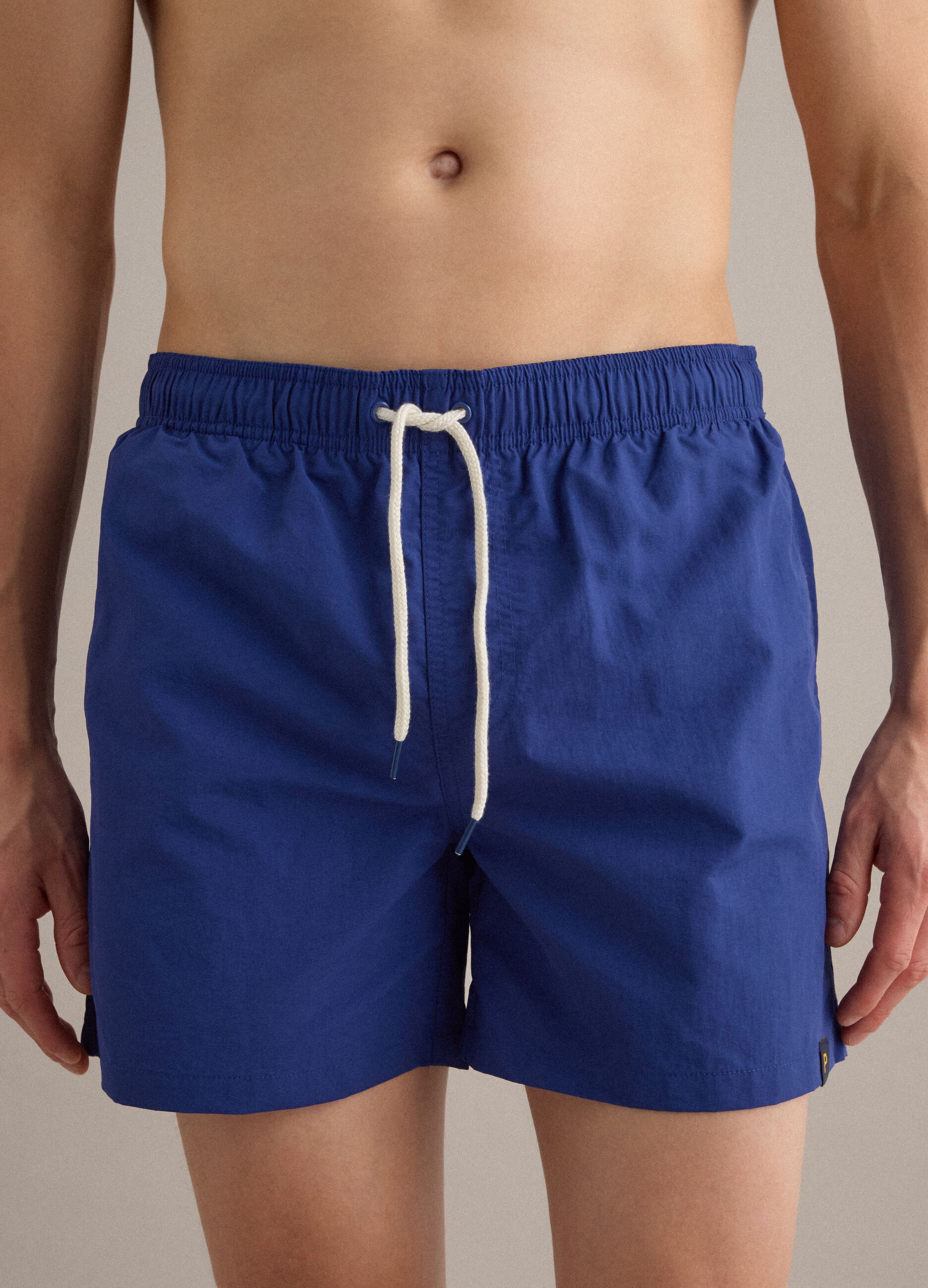 Blue swim shorts with elasticated waist and drawstring