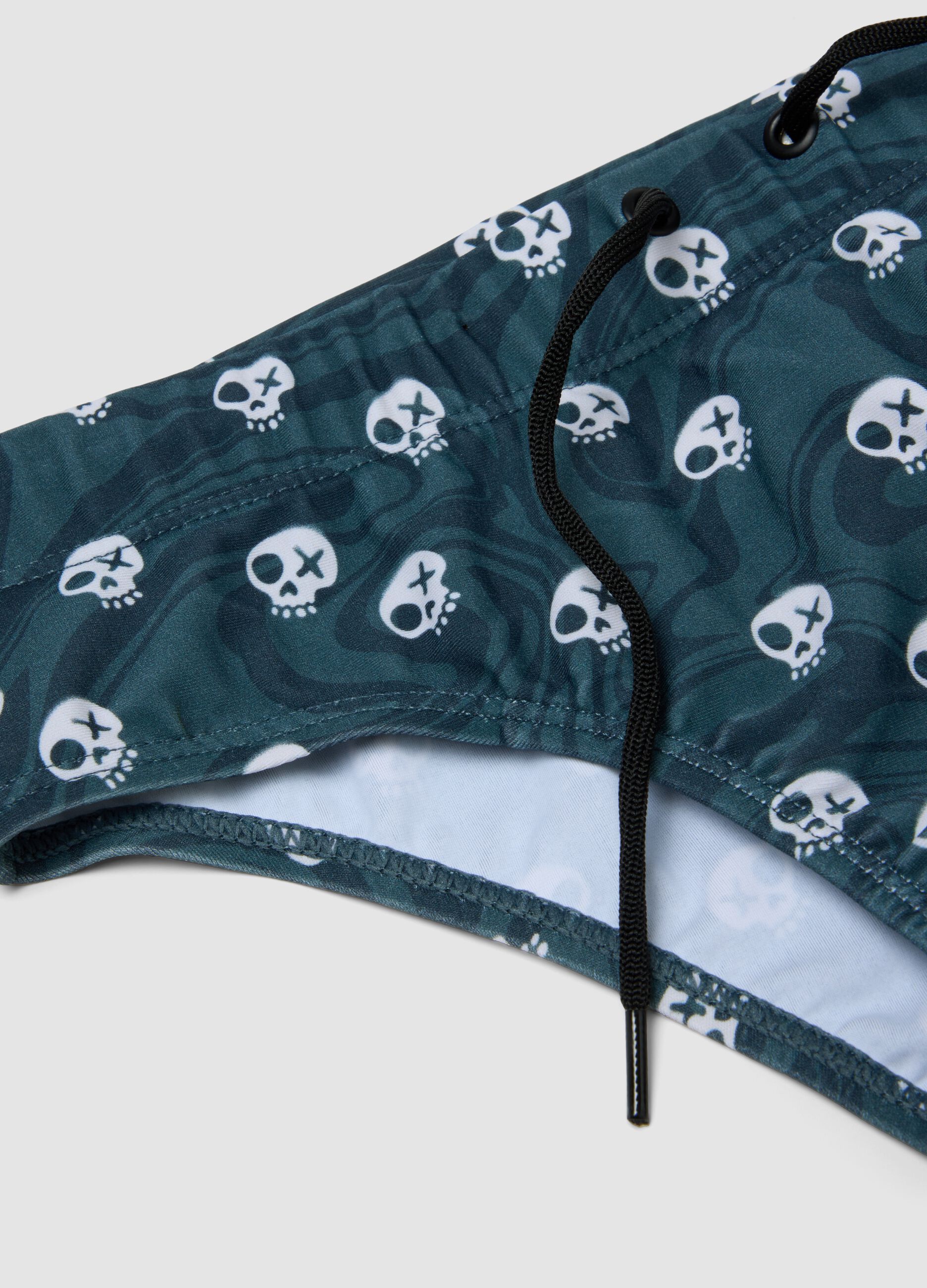 Blue stretch swim briefs with skull print