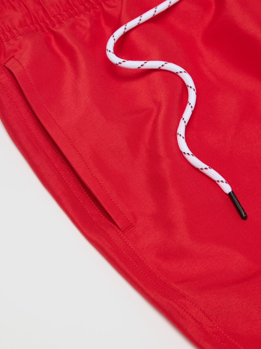 Red swimming trunks with logo print_5