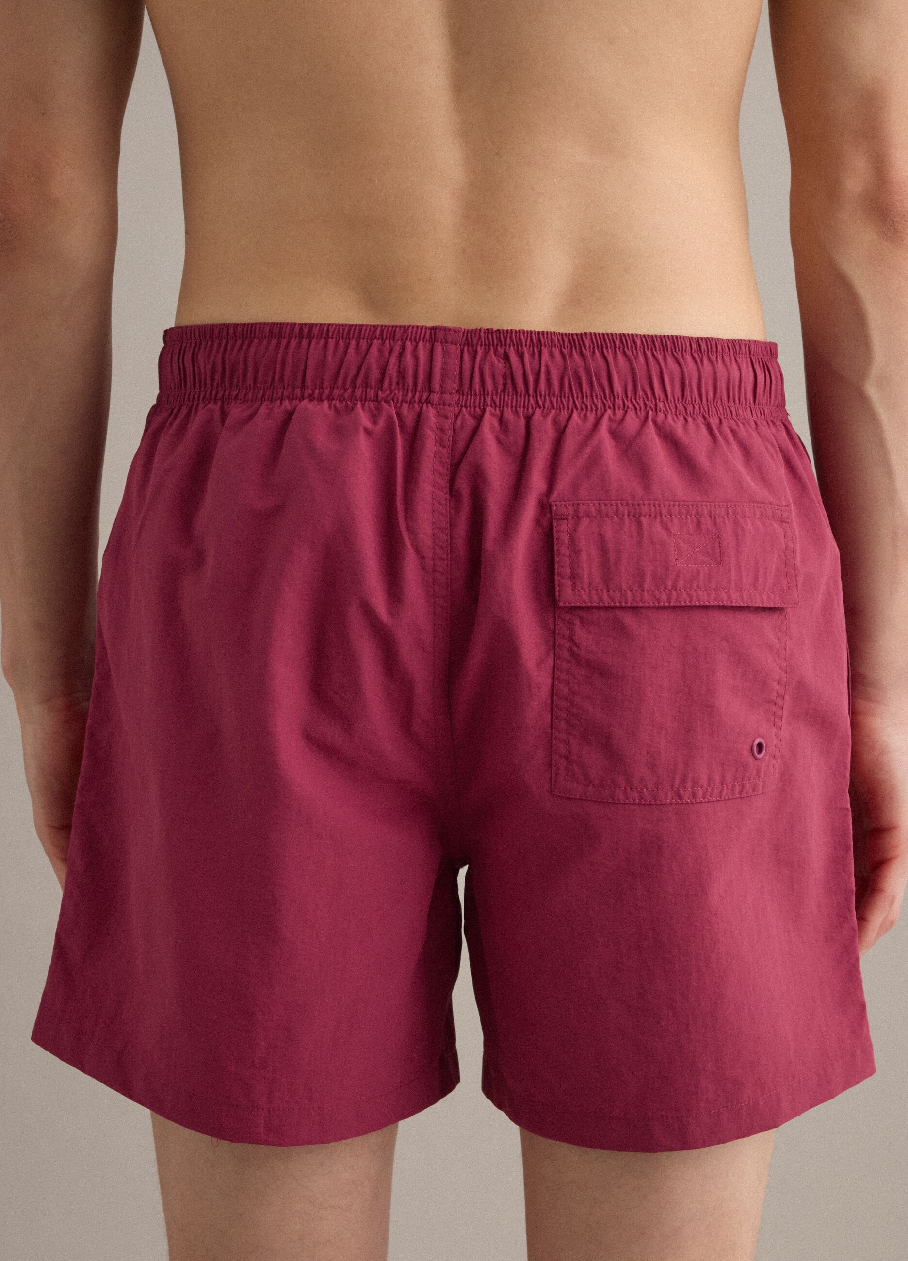 Red swim shorts with elasticated waistband and drawstring