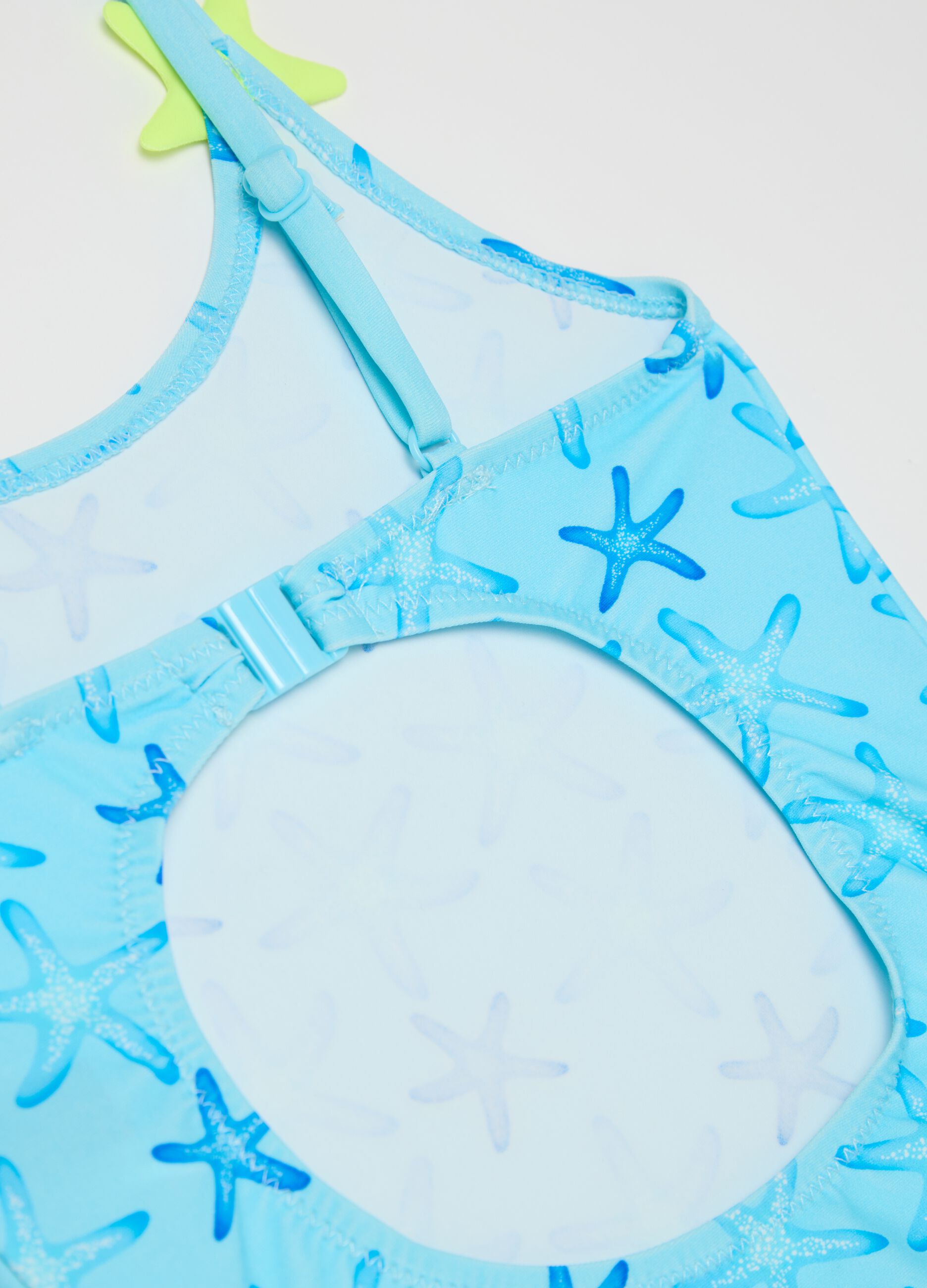 Girls’ one-piece swimsuit in light blue stretch fabric with starfish design
