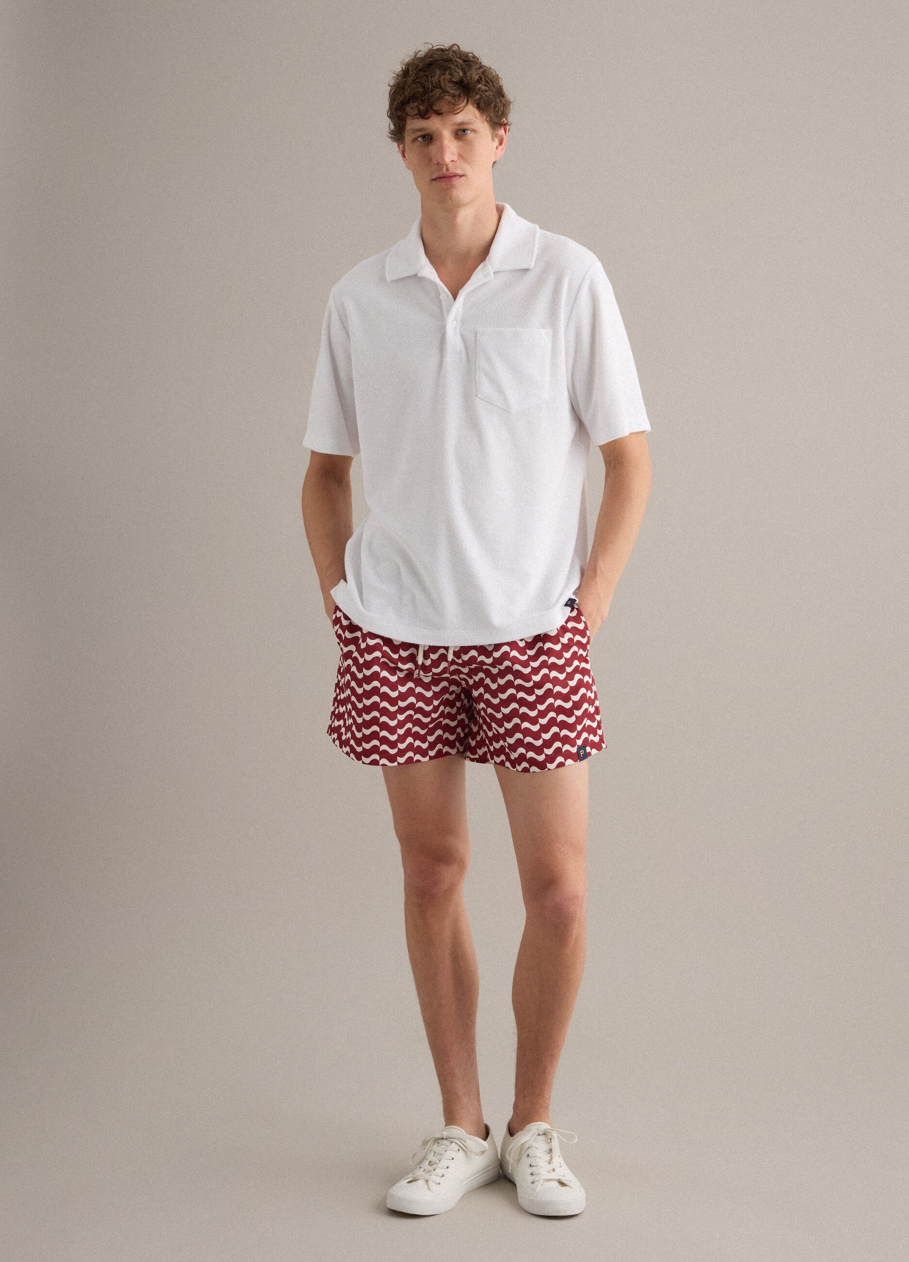 Red men&rsquo;s swim shorts with all-over print